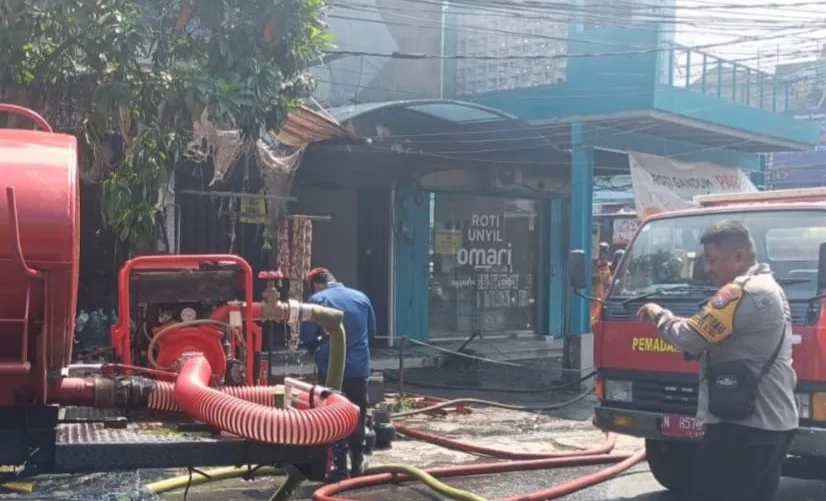 Foto: Istimewa (Proses pemadaman bangunan toko kelontong di Simpang Empat Galunggung Kota Malang yang terbakar, Selasa (22/9/2026) pagi.)