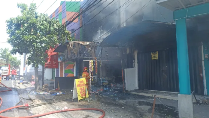 Foto: Istimewa (Proses pemadaman bangunan toko kelontong di Simpang Empat Galunggung Kota Malang yang terbakar, Selasa (22/9/2026) pagi.)